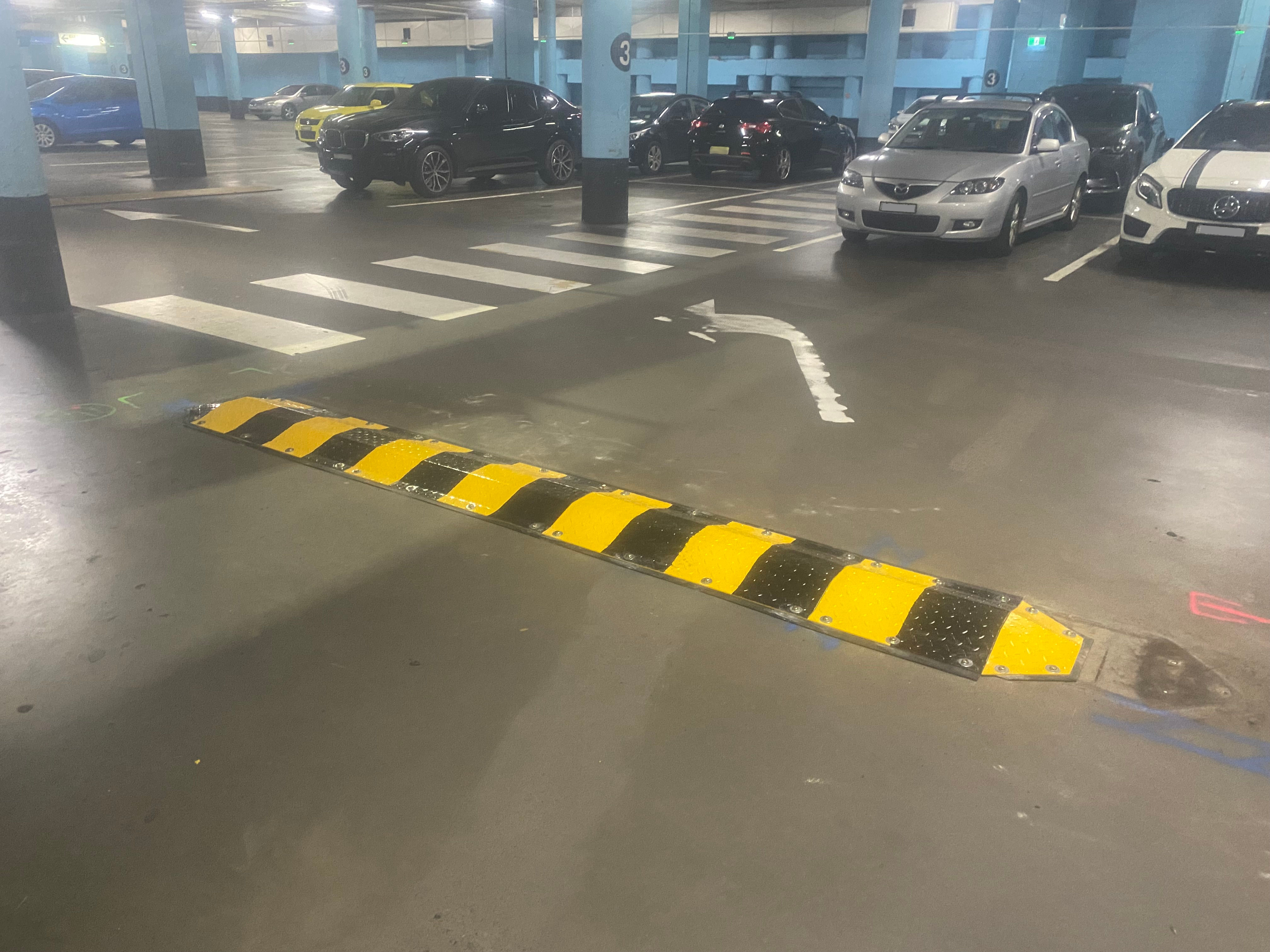 Steel speed humps installed on car park surface.